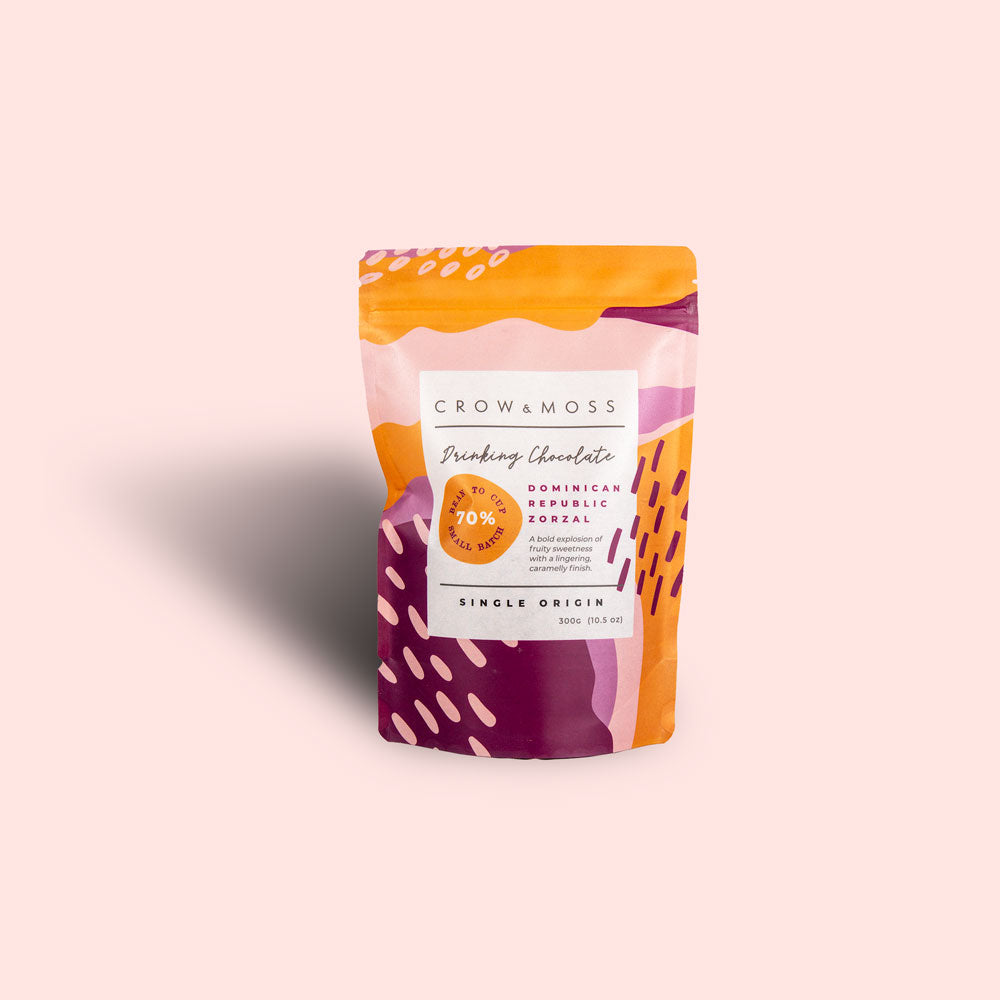 Image of a standup pouch of Dominican Republic Zorzal Drinking Chocolate 70% on a subtle pink background.