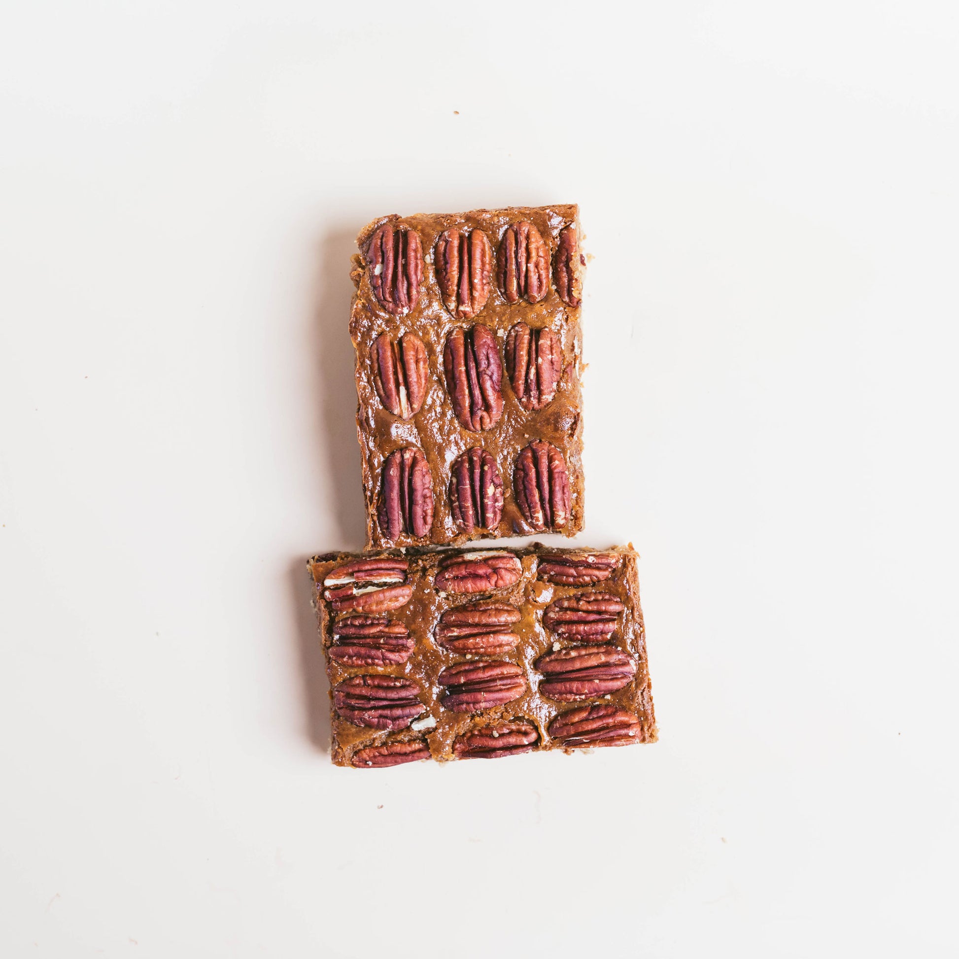 2 Pecan Pie Blondie Bars from overhead on a white background.