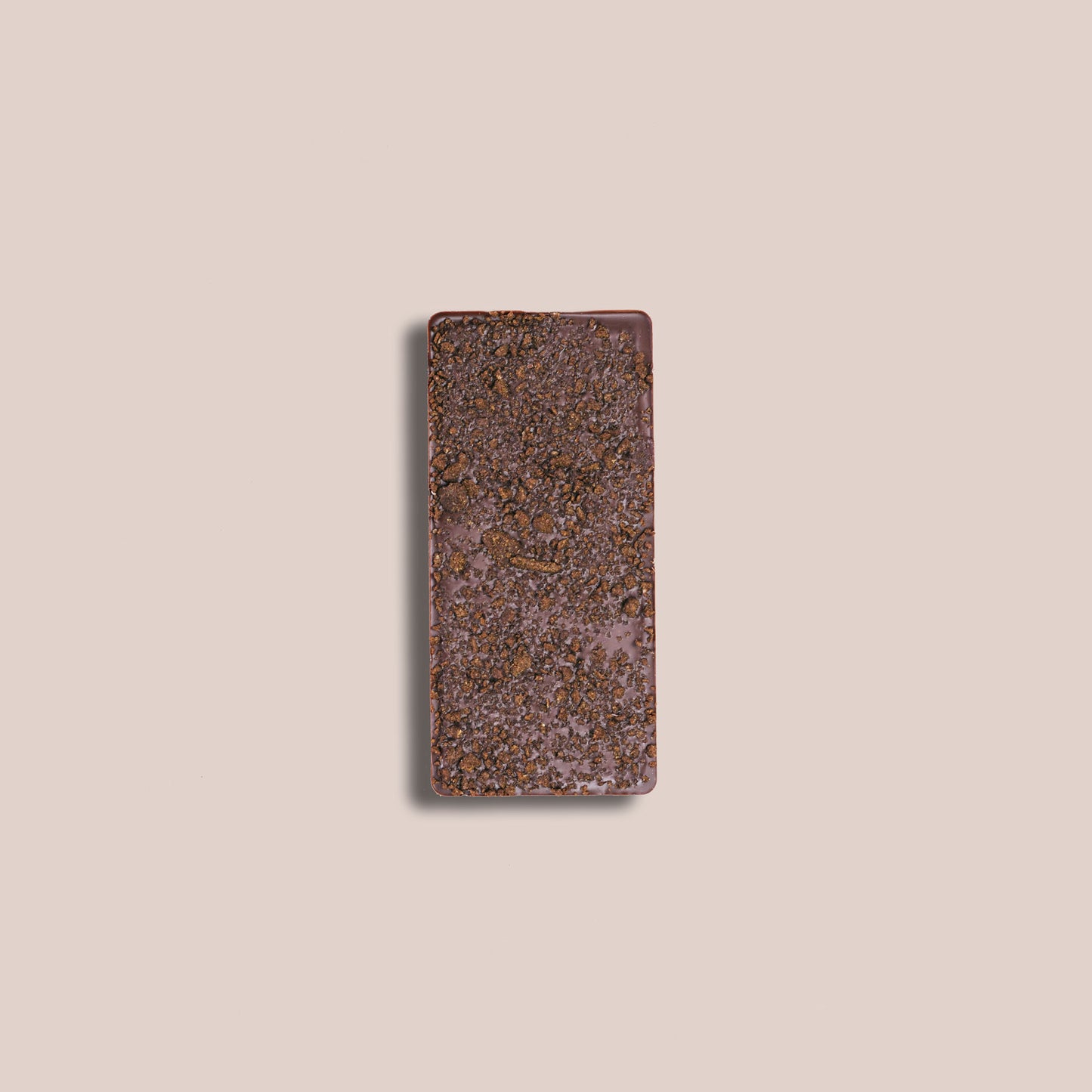 Image of the back of a bar of our Gingersnap Cookie and Oat Mylk Bar 40% depicting the crumbled cookie bits embedded in the back of bar of chocolate.
