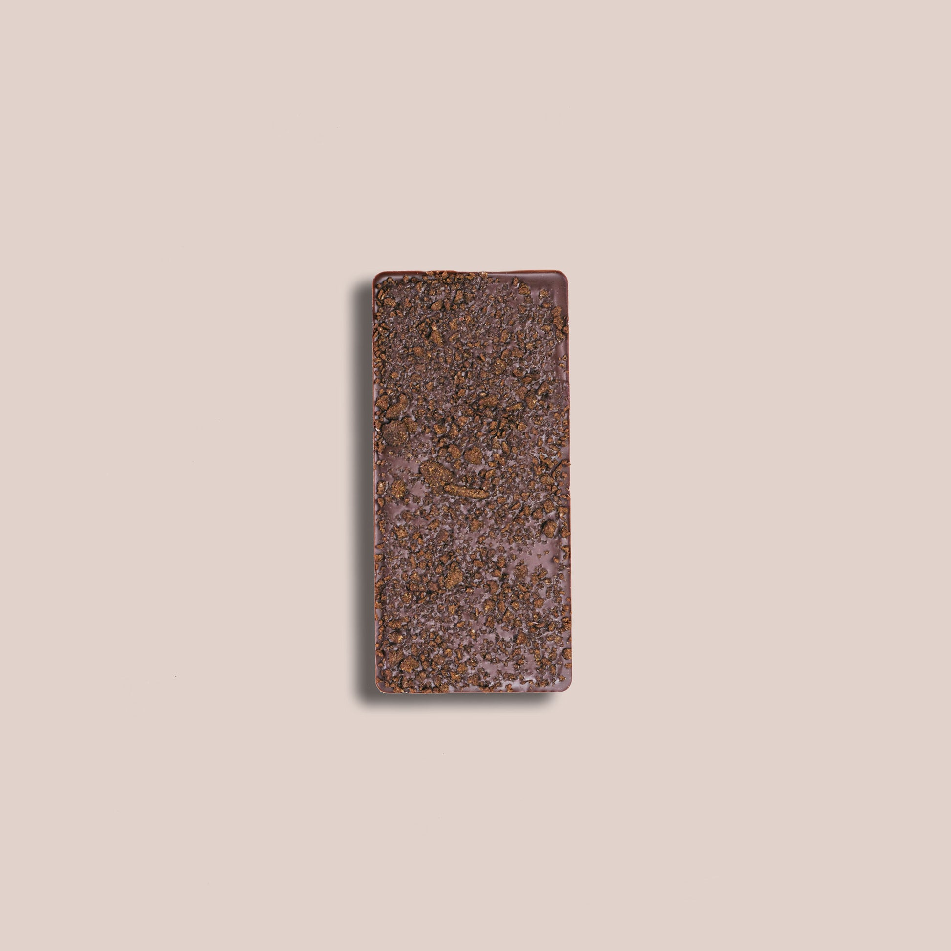 Image of the back of a bar of our Gingersnap Cookie and Oat Mylk Bar 40% depicting the crumbled cookie bits embedded in the back of bar of chocolate.