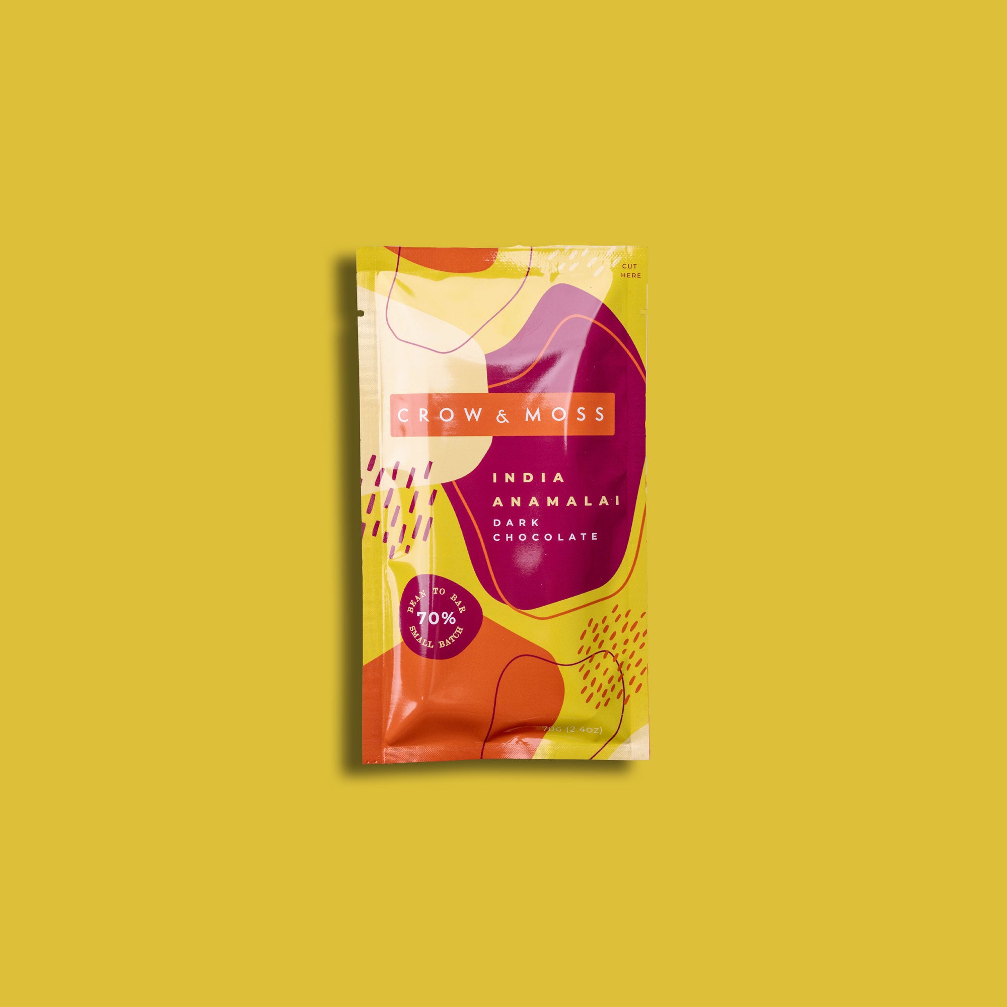 Image of the front of the packaging of our India Anamalai Dark Chocolate Bar 70% on a yellow background.